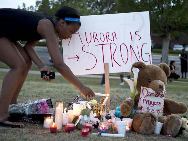 Mourners at a vigil light candles near theater where 12 people were killed in Aurora, Colorado. (AFP photo/Don Emmert)