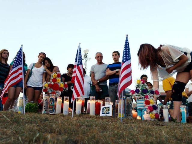 People light candles at a makeshift memorial during a vigil for victims at the Century 16 movie theatre where a gunmen attacked movie goers during an early morning screening of the new Batman movie, "The Dark Knight Rises" in Aurora, outside of Denver, Colorado. (Kevork Djansezian/Getty Images/AFP)