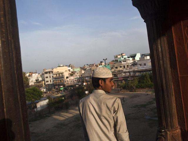 A Muslim boy looks at the residential complex through the Jama Masjid (Grand Mosque) before having his Iftar (fast-breaking) meal during the holy month of Ramadan in the old quarters of Delhi. (Reuters)