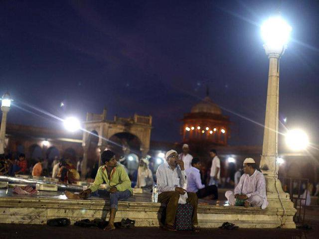 Muslims sit after having their Iftar (fast-breaking) meal during the holy month of Ramadan at the Jama Masjid (Grand Mosque) in the old quarters of Delhi. (Reuters)