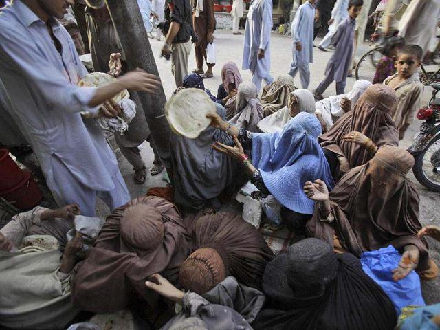 A Pakistani man, left, delivers free bread to women to break their fast on the first day of the holy fasting month of Ramadan, in Peshawar, Pakistan. (AP Photo)
