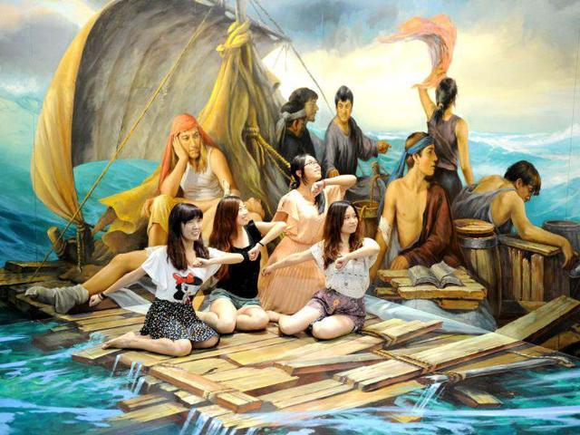 This picture shows visitors posing with a "3D painting" at the Magic Art Special exhibition at the Hangzhou Peace International Exhibition and Conference Centre in the eastern Chinese city of Hangzhou.(AFP photo/Peter Parks)