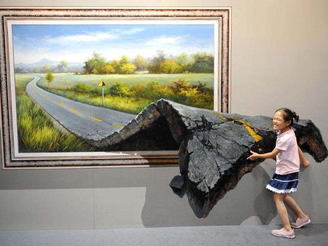 This picture shows a visitor posing with a "3D painting" at the Magic Art Special exhibition at the Hangzhou Peace International Exhibition and Conference Centre in the eastern Chinese city of Hangzhou. (AFP photo/Peter Parks)