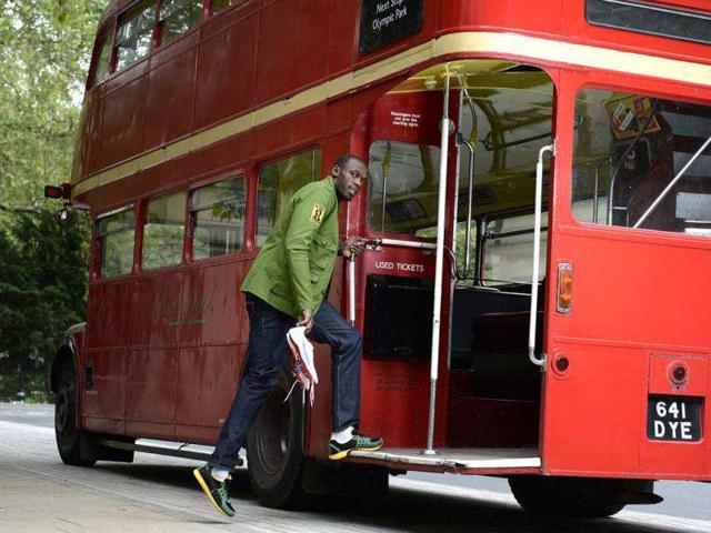 Sprinter Usain Bolt of Jamaica poses with his running spikes and official team uniform for the London 2012 Olympic Opening Ceremony during a photo shoot, arranged by his sponsors PUMA, beside a traditional routemaster bus outside the British Museum in London. Reuters/Dylan Martinez