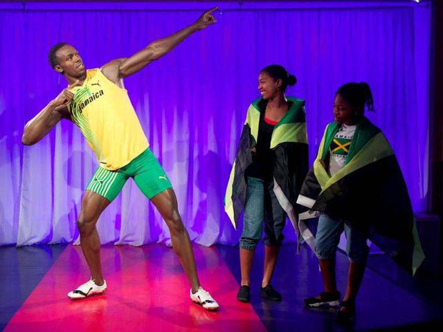 Two girls wrapped in Jamaican flags look at the waxwork of Jamaican sprint star Usain Bolt during the unveiling at London's Madame Tussauds museum, four days before the start of the 2012 London Olympic Games. AFP Photo/Andrew Cowie