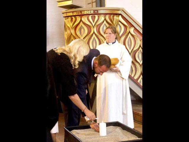Norway's Prince Haakon and Princess Mette-Marit light a candle in Hole Church near Utoeya island during a remembrance ceremony on the anniversary of the massacre. (AFP/Terje Bendiksby)