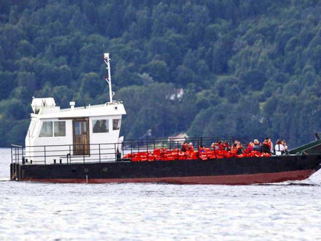 Bereaved families and friends of the 69 people who were gunned down and killed at Uoeya Island in the Tyrifjord a year ago, are ferried across to the island on the first anniversary of the massacre. (AFP/Vegard Groett)