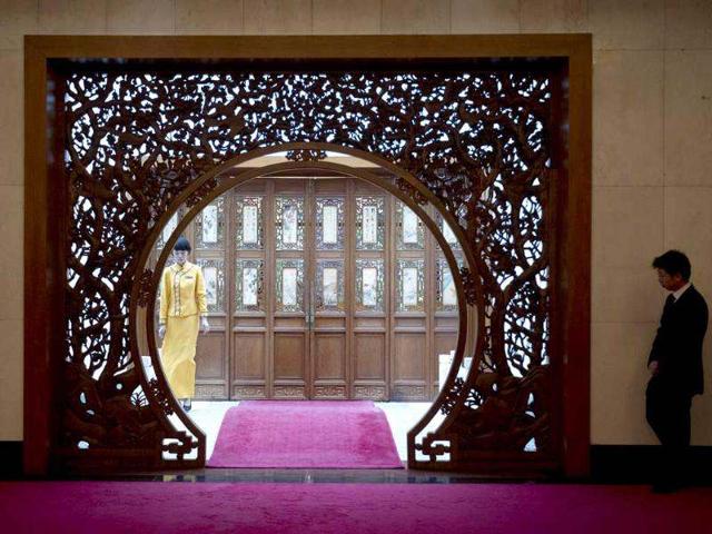A hostess, left, and an unidentified official, stand outside closed doors of a room where Chinese state councillor Dai Bingguo is waiting to greet visiting US national security advisor Tom Donilon at the Diaoyutai State Guesthouse in Beijing. AP/Alexander F Yuan