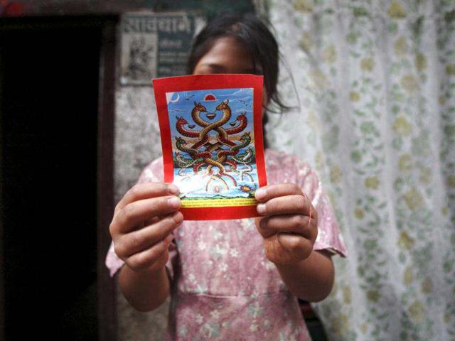 A girl shows a picture of a snake god during the "Nag Panchami" festival (or snake festival) in Kathmandu. Hindus in Nepal, India and Bangladesh celebrate the festival by worshipping snakes to honour the serpent god. REUTERS/Navesh Chitrakar
