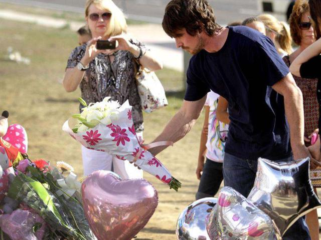 Actor Christian Bale place flowers on the memorial to the victims of Friday's mass shooting in Aurora, Colorado.