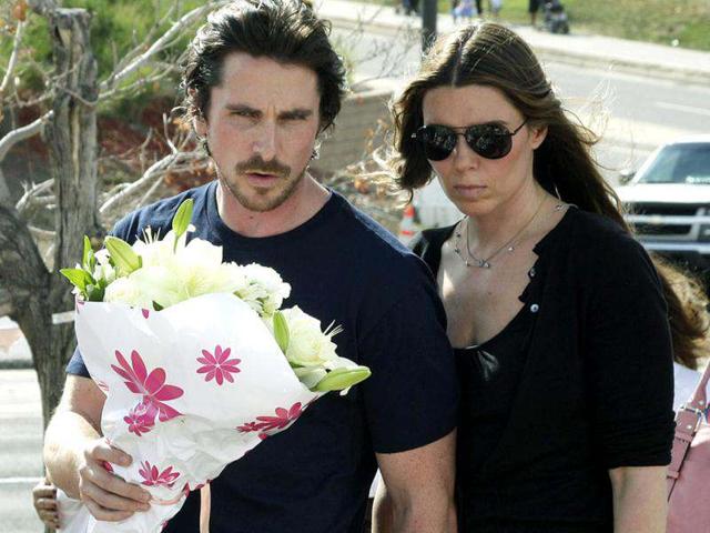 Actor Christian Bale and his wife Sandra Blazic look at the flowers and cards at the memorial across the street from the Century 16 movie theater.