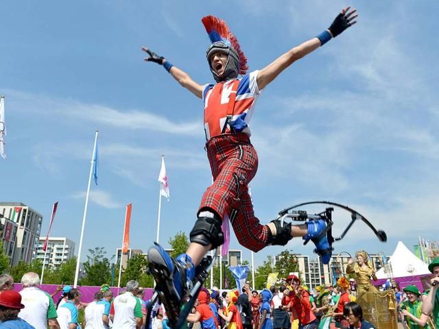 An artist performs on jumping stilts during an arrival ceremony for athletes at the Olympic Village in London, two days before the start of the London 2012 Olympic Games. AFP/Adek Berry