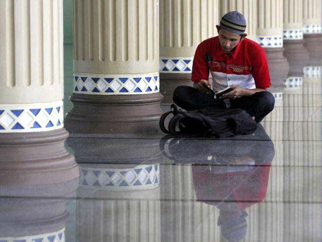 A man reads a Muslim holy book of Quran at a mosque in Banda Aceh, Indonesia. Muslims around the globe are observing Ramadan, the holiest month in Islamic calendar, when they refrain from eating, drinking, smoking and sex from dawn to dusk. AP/Heri Juanda