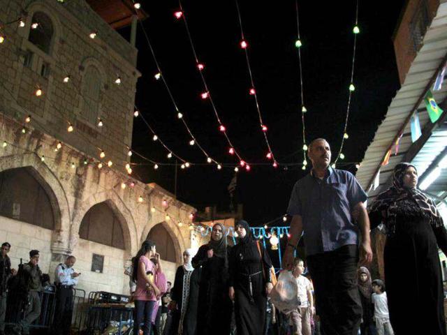 People walk in an alley decorated for the holy month of Ramadan in Jerusalem's Old City. Reuters/Ammar Awad