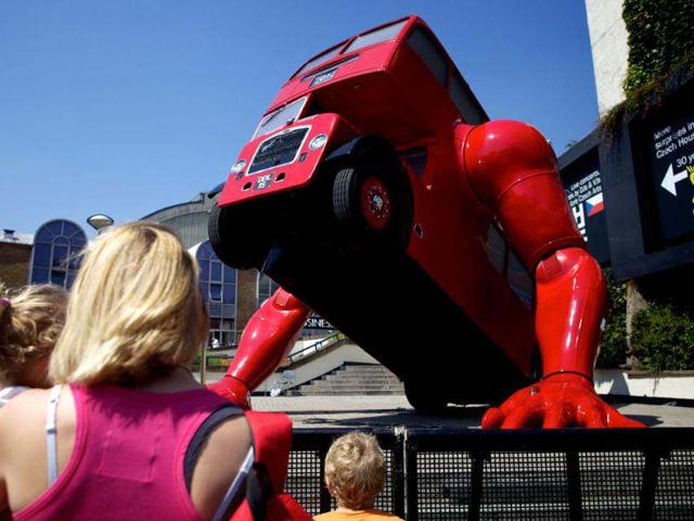 A woman and children look at David Cerny's double-decker bus art installation "London Booster". The Czech artist has adapted a 1957 London bus and added huge mechanical arms which enable it to do press-ups. (AFP photo/Andrew Cowie)