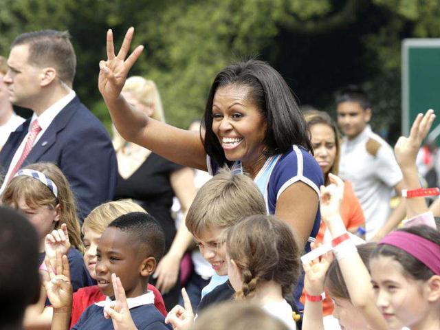 US first lady Michelle Obama poses for photos with schoolchildren during a 'Let's Move!' event for about 1,000 American military children and American and British students at the US ambassador's residence in London, ahead of the 2012 Summer Olympics. (AP Photo/Lefteris Pitarakis)