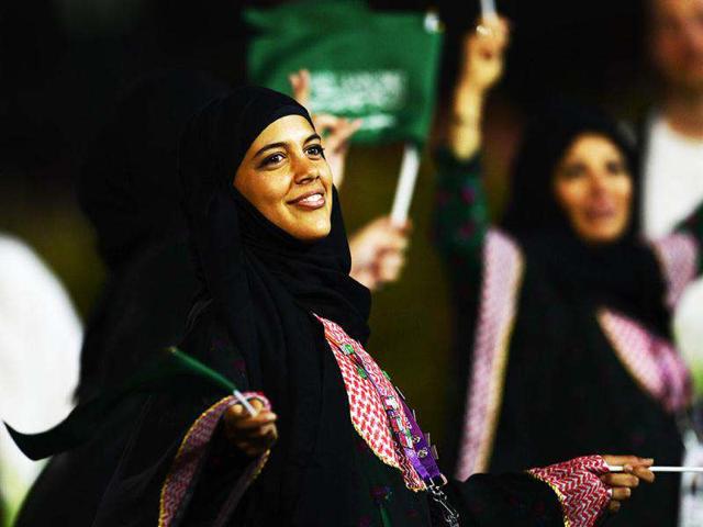 A member of the Saudi Arabia's delegation waves national flags as she parades during the opening ceremony of the London 2012 Olympic Games at the Olympic Stadium in London. AFP/Adrian Dennis