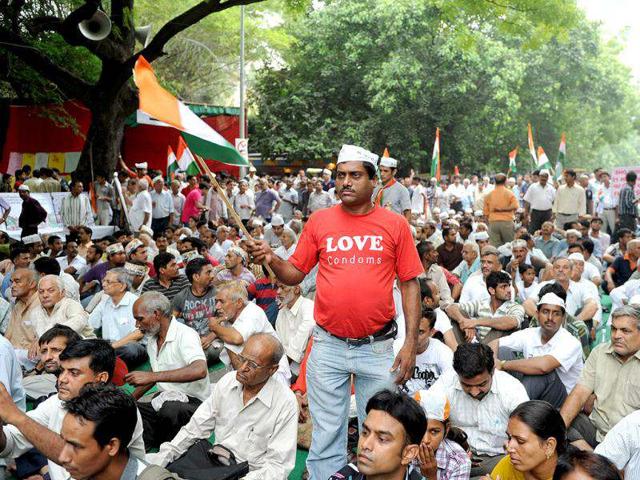 A supporter of anti-corruption activist Anna Hazare waves the Indian national flag gather during a rally where Hazare began his hunger strike in New Delhi. (AFP Photo/Sajjad Hussain)