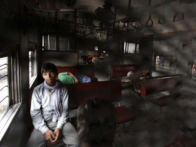 A passenger sits as others sleep inside the compartment of a stationary train following the power outage that struck north India. AP photo/Altaf Qadri