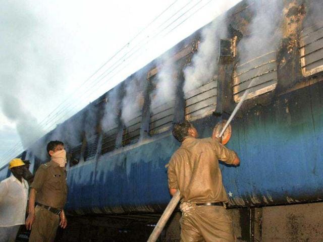 A fire fighter douses fire coming out from a coach of a passenger train at Nellor nearly 500 kilometers (310 miles) south of Hyderabad. AP Photo