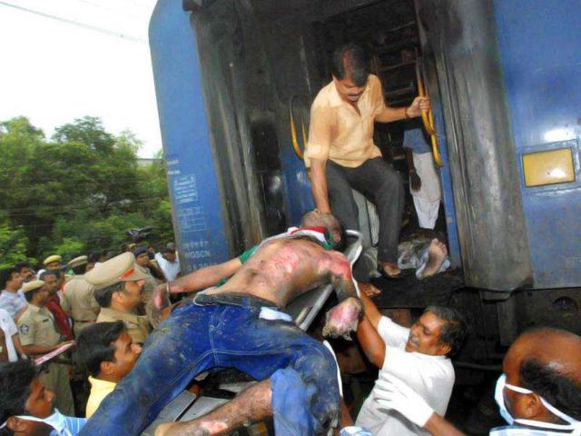 Indian Railway officials take out a body of a passenger from a burnt coach of a passenger train, at Nellor nearly 500 kilometers (310 miles) south of Hyderabad. AP Photo