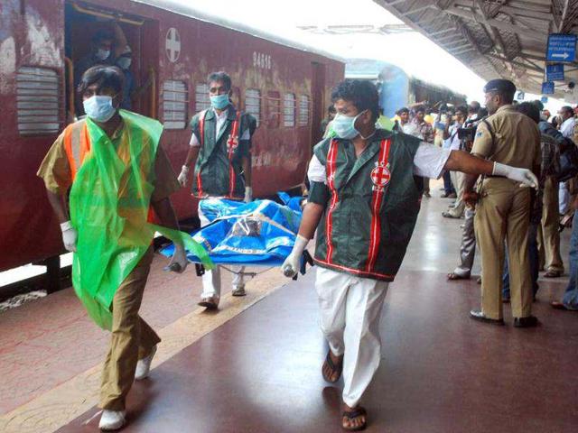 Medical staff carry away the body of a passenger killed in a train carriage fire, caused by an electrical short circuit killing at least 32, in Nellore. AFP photo