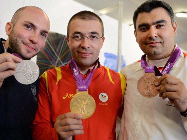 Gold medallist Alin George Moldoveanu (C) of Romania, silver medallist Niccolo Campriani of Italy (L) and bronze medallist Gagan Narang pose on the podium during the medal ceremony following the Men's 10m Air Rifle shooting final . (PTI Photo/Manvender Vashist)