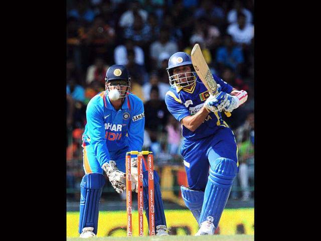 Sri Lankan cricketer Tillakaratne Dilshan (R) plays a shot as wicketkeeper Mahendra Singh Dhoni looks on during the fourth one day international (ODI) match between Sri Lanka and India at the R Premadasa Cricket Stadium in Colombo. AFP Photo/Lakruwan Wanniarachchi