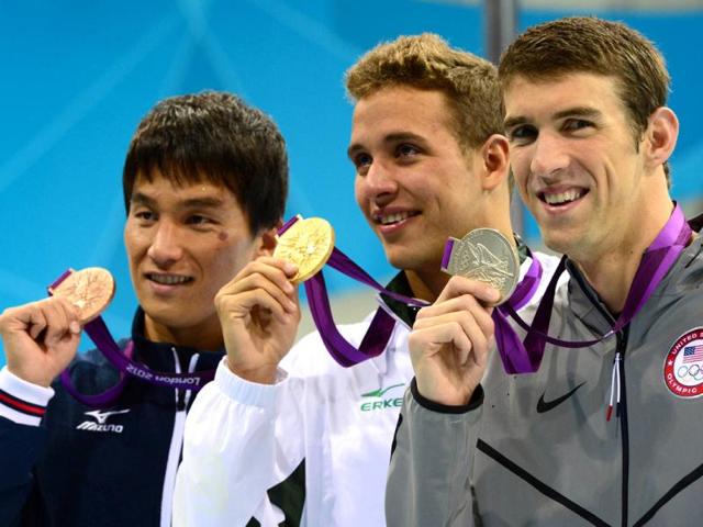 Gold medalist South Africa's Chad Le Clos (C), bronze medalist Japan's Takeshi Matsuda (L) and silver medalist US swimmer Michael Phelps (R) celebrate on the podium of the men's 200m butterfly final during the swimming event at the London 2012 Olympic Games in London. AFP photo/Christophe Simon