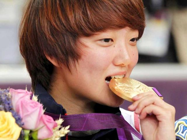 South Korea's Kim Jangmi bites her gold medal after the victory ceremony for the women's 25m pistol shooting event at the London 2012 Olympic Games at the Royal Artillery Barracks. Reuters/Mike Hutchings