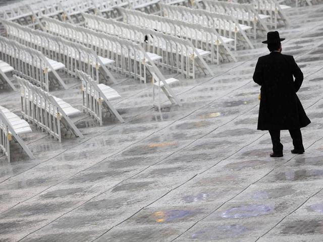 An Orthodox Jew stands near chairs as he arrives for the 12th Siyum Hashas, a celebration marking the completion of the Daf Yomi, a seven-year cycle of studying texts from the Talmud, the canon of Jewish religious law, at the MetLife Stadium in East Rutherford, New Jersey. Reuters photo/Eric Thayer