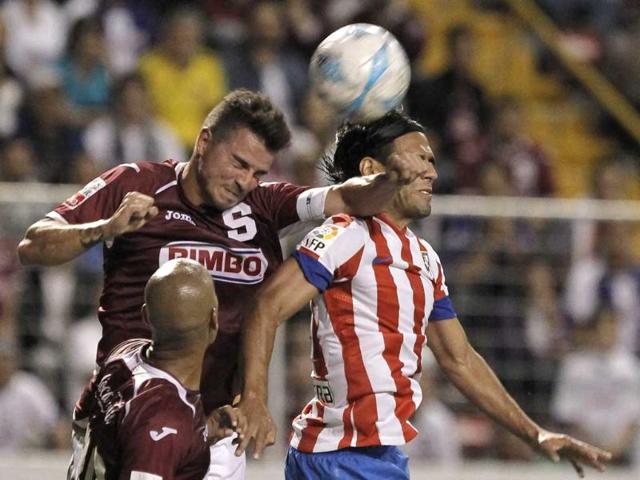 Radamel Falcao of Spain's Atletico Madrid jumps for the ball against Gabriel Badilla of Costa Rica's Deportivo Saprissa during their international friendly soccer match at the Ricardo Saprissa stadium in San Jose. Reuters/Juan Carlos Ulate