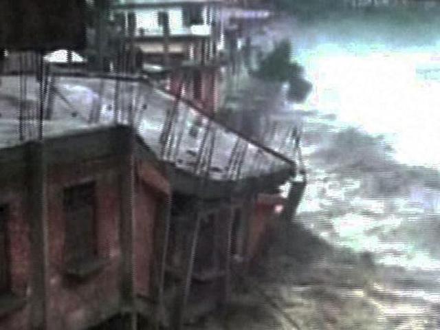 A TV grab shows houses being washed away in cloudbursts and floods in Uttarkashi. (PTI Photo)