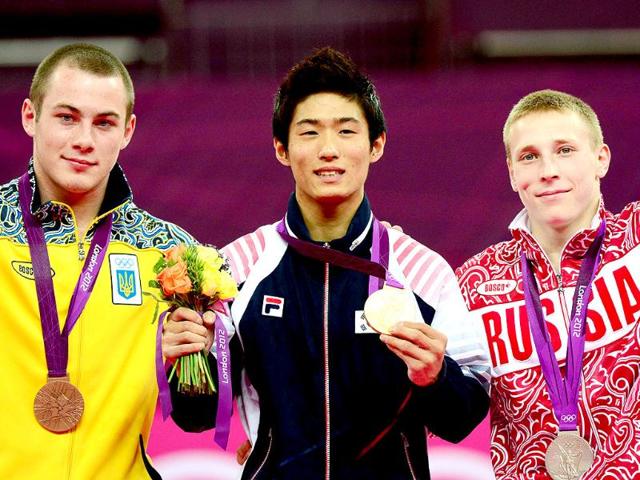 Gold medalist South Korea's gymnast Yang Hak Seon (C), silver medalist Russia's gymnast Denis Ablyazin (R) and bronze medalist Ukraine's gymnast Igor Radivilov celebrate on the podium of the men's vault of the artistic gymnastics event of the London Olympic Games at the 02 North Greenwich Arena in London. (AFP photo/Emmanuel Dunand)