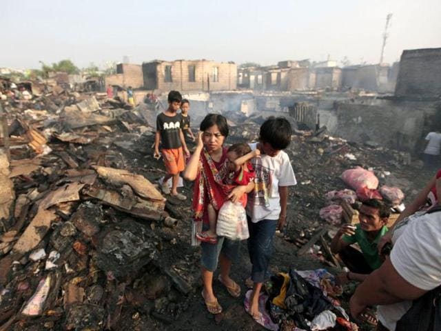 Residents examine a gutted neighborhood after a fire in Jakarta, Indonesia. Nearly 500 houses in the densely packed area are reported destroyed in the fire. AP Photo/Dita Alangkara