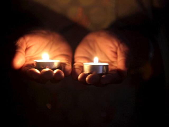 A mourner holds two candles during a vigil at the Sikh Religious Society of Wisconsin for the victims of the shooting at the Sikh Temple of Wisconsin the previous day in Brookfield, Wisconsin. Darren Hauck/AFP