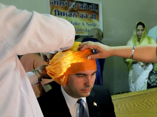 Wisconsin governor Scott Walker, is fitted with a head covering, by members of the Sikh community as he prepares to worship with them at the Sikh Religious Society of Wisconsin in Brookfield. AP/M Spencer Green