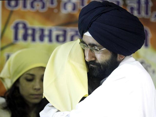 Worshipers in the Sikh community comfort each other as they prepare for a prayer service at the Sikh Religious Society of Wisconsin in Brookfield. AP/M Spencer Green