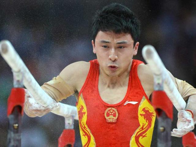 China's gymnast Feng Zhe performs to win gold in the men's parallel bars competition of the artistic gymnastics event of the London Olympic Games on August 7, 2012 at the 02 North Greenwich Arena in London. (AFP photo/Ben Stansall)
