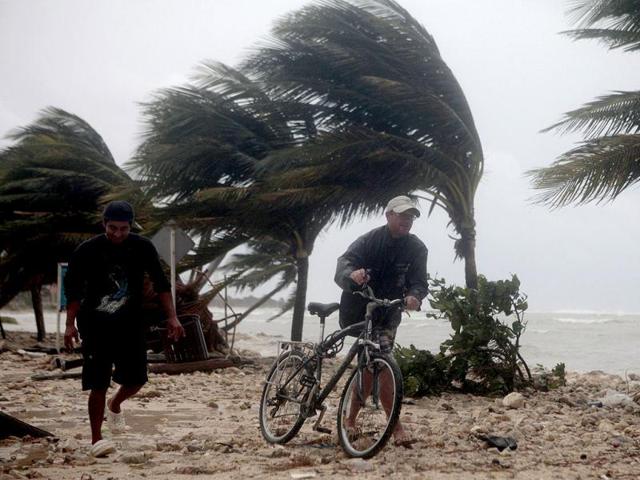 Residents walk past swaying palm trees following the passing of Hurricane Ernesto in Mahahual, in the Mexican state of Quintana Roo. Reuters Phhoto