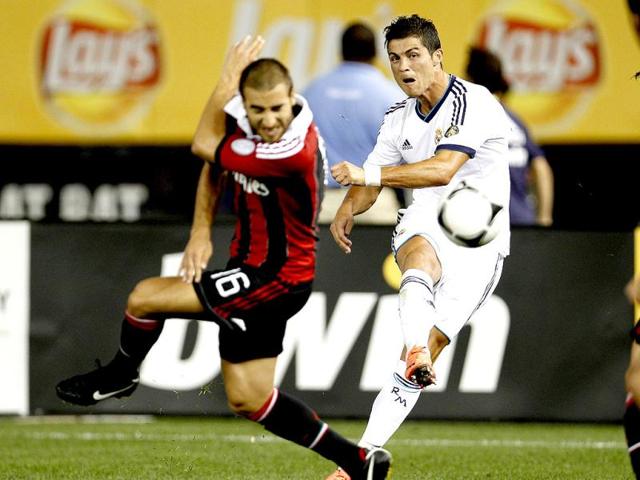 Real Madrid's Cristiano Ronaldo (R) takes a shot defended by AC Milan's Mathieu Flamini in the second half of their team's friendly soccer match at Yankee Stadium, the home of the New York Yankees baseball team, in New York. Reuters/Adam Hunger