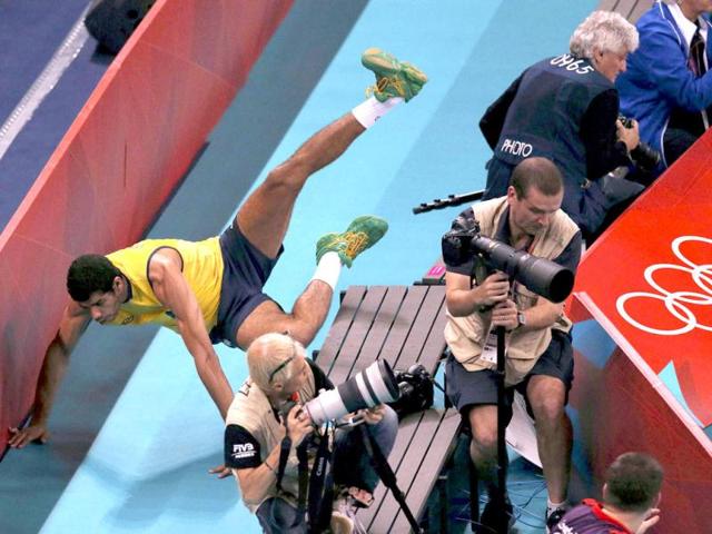 Brazil's Wallace de Souza crashes through the barrier while chasing the ball during their men's quarterfinal volleyball match against Argentina at Earls Court during the London 2012 Olympic Games. Reuters/Ivan Alvarado