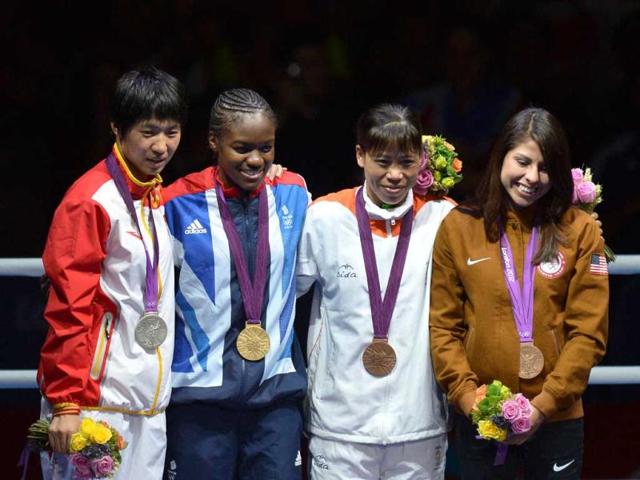 Gold medalist Britain's Nicola Adams (2D-L), silver medalist China's Cancan Ren, bronze medalists Marlene Esparza from the US and India's Chungneijang Mery Kom Hmangte celebrate on the podium of the the women's boxing Flyweight final of the 2012 London Olympic Games at the ExCel Arena in London. AFP/Alberto Pizzoli