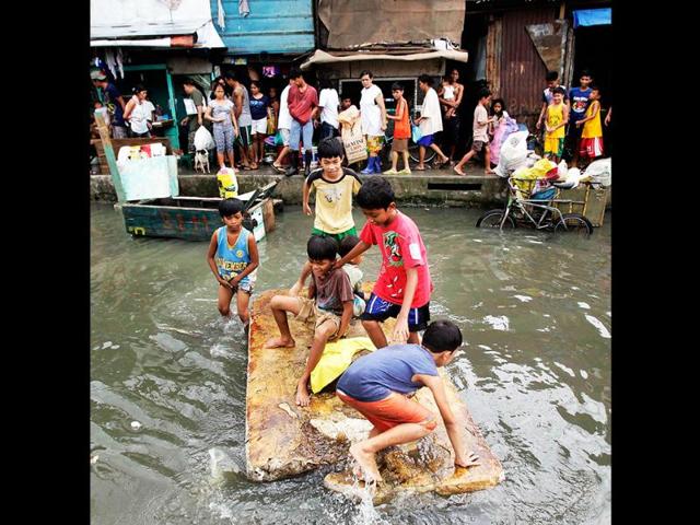 Children play in a makeshift raft on floodwaters in Malabon, Metro Manila. The death toll in nearly two weeks of steady monsoon rains in the Philippine capital and nearby provinces had climbed to more than 100 people, while more than two million people were affected by the worst flooding in three years, disaster officials said. Reuters/Erik De Castro