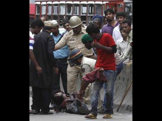Police check on an injured person after the mob become violent during the protest against Muslim killings Assam at Azad Maidan in Mumbai, India.(HT/Anshuman Poyrekar)