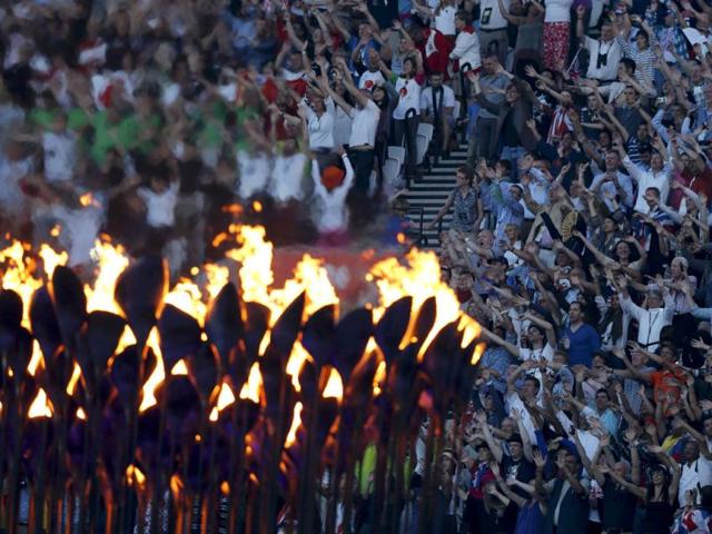 Guests take part in a 'wave' as the Olympic Torch burns during the closing ceremony of the London 2012 Olympic Games at the Olympic Stadium. (Reuters/Chris Helgren)