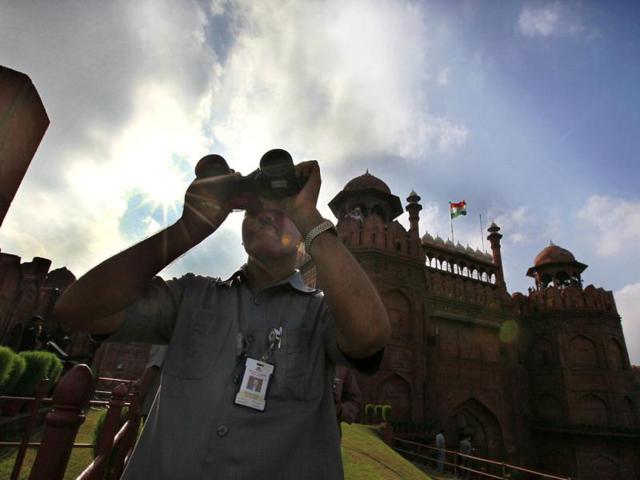 A security person uses a binocular to keep vigil Red Fort during the full dress rehearsal of Independence Day celebrations in New Delhi. HT photo/Raj K Raj