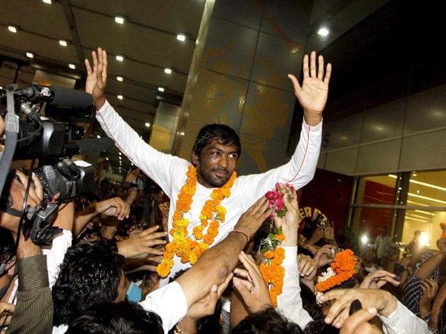 Wrestler Yogeshwar Dutt ,Olympics bronze medalist in the men's 60kg freestyle event, gestures on his arrival at IGI airport in New Delhi. (Arijt Sen/HT Photos)