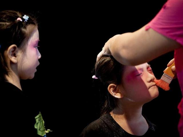 A girl is applied makeup before a training at Peking Opera summer camp organized by the Peking Opera House in Beijing, China. AP/Andy Wong