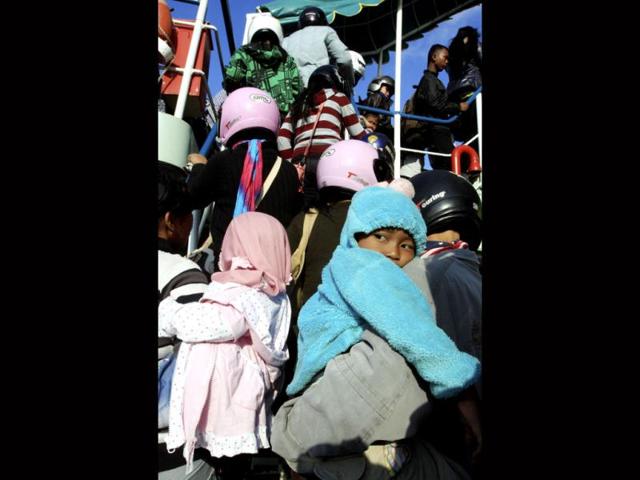 A Muslim girl is carried by her father as they board a ferry boat for home at Gilimanuk port, west Bali, Indonesia. A mass exodus out of the capital and other major cities in the world's most populous Muslim country is underway as millions are heading their home villages to celebrate Eid ul-Fitr holiday. (AP/Firdia Lisnawati)